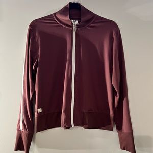 Vuori burgundy zip up with white stripes on sleeves.